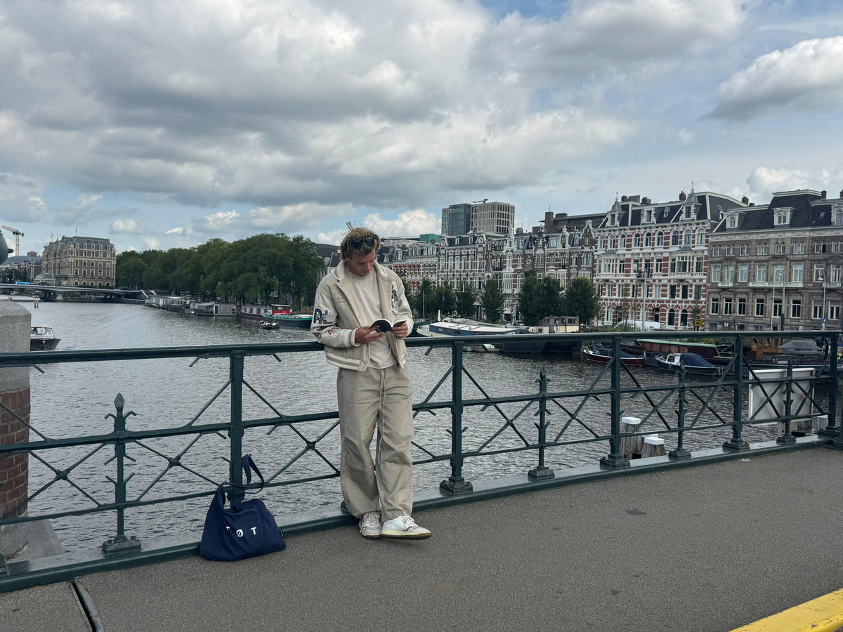 A quiet morning on an Amsterdam bridge, the Amstel and a wide cloudy sky behind