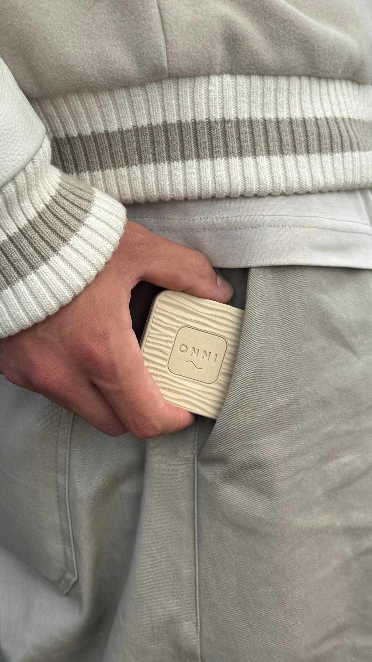 The Classic Birch Kiuas, wood-grain wave and ONNI mark, held at the pocket