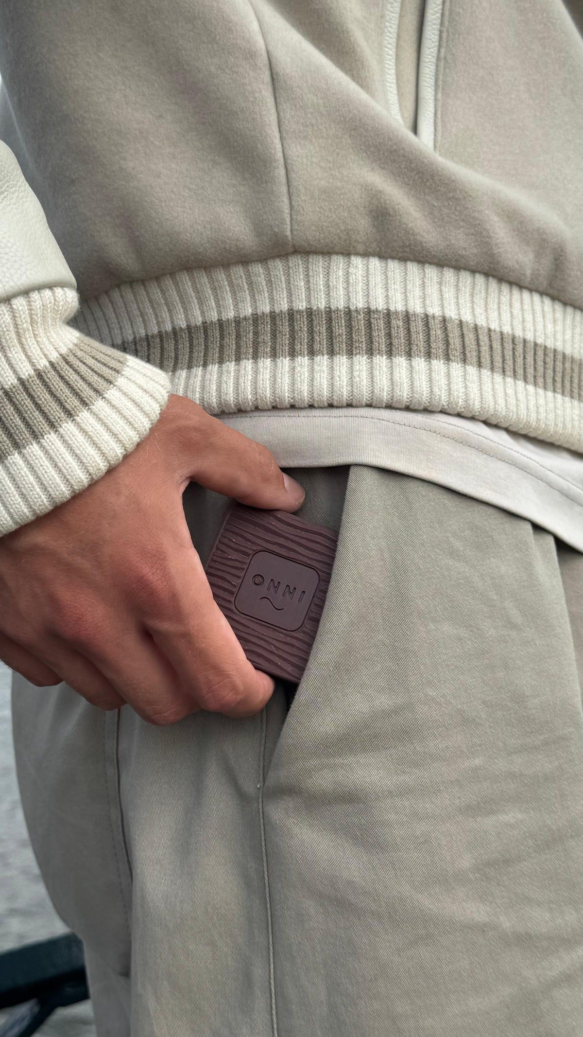 The Black Walnut Kiuas, deep brown with the wave mark, at the pocket