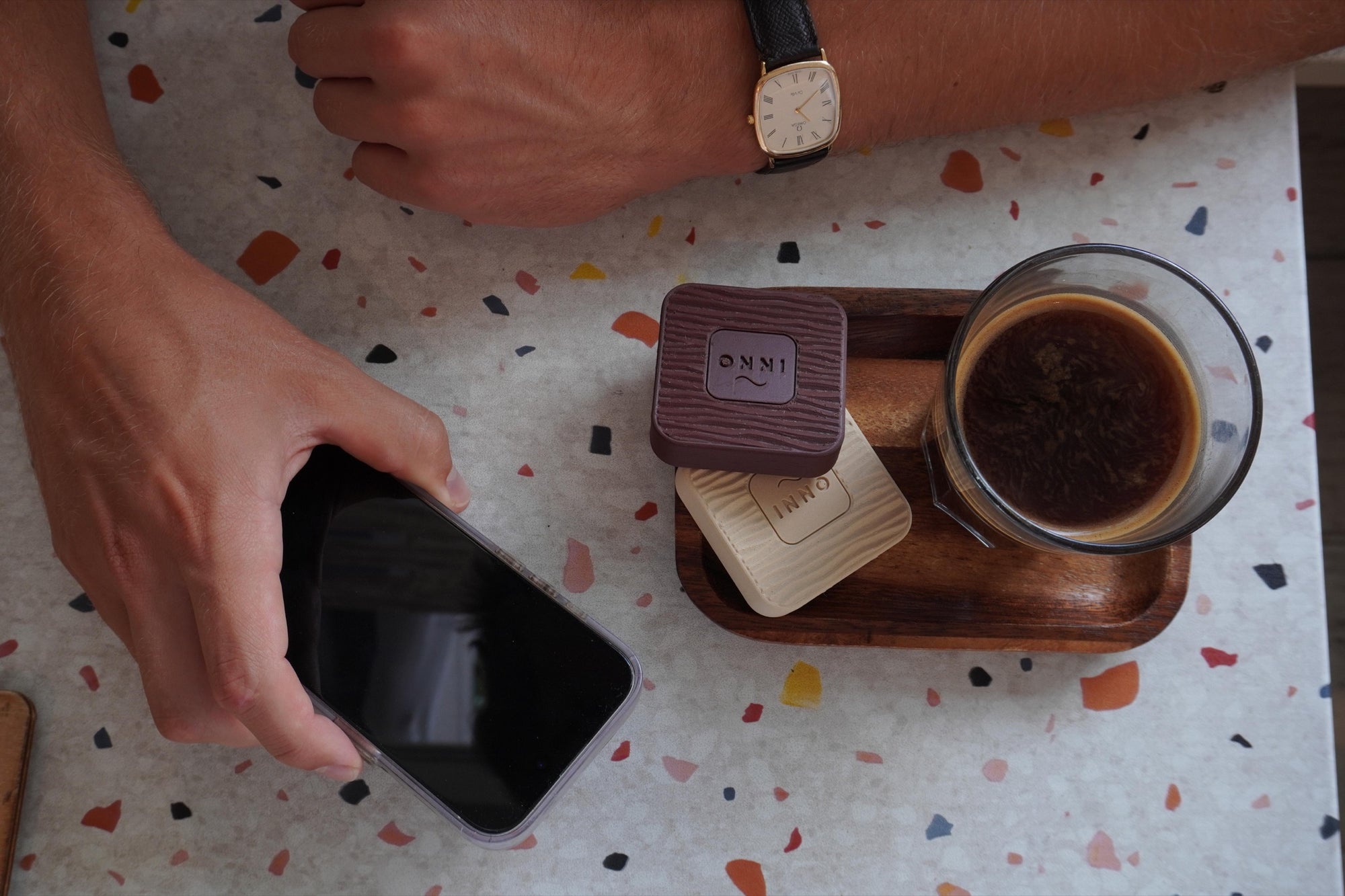 A quiet café moment with coffee, a phone and the Kiuas