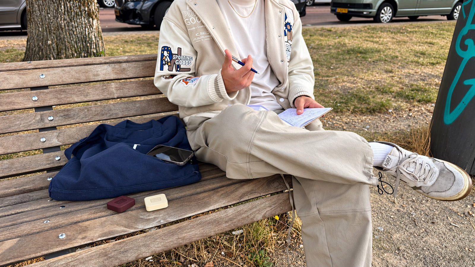 Writing in a notebook on a park bench in the afternoon sun